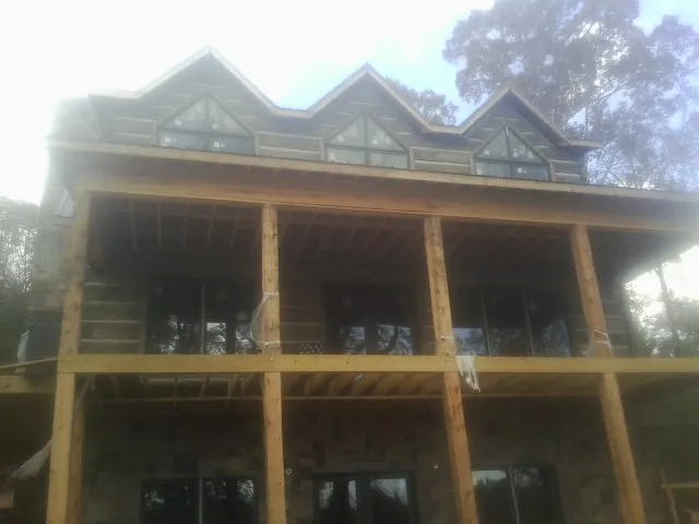 Dormers and porch framing on a large log home under construction — Roof Coating work by our crew in Richland